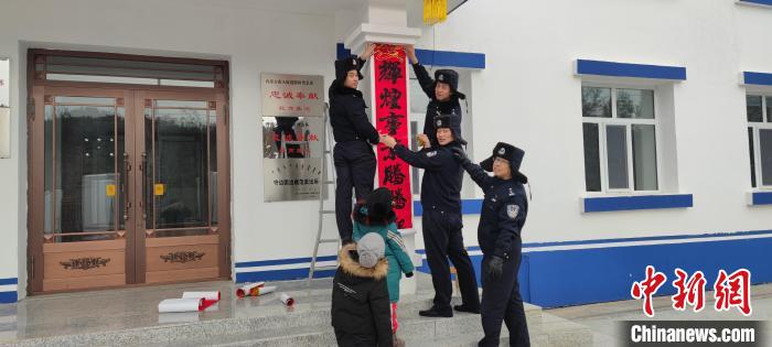 圖為恩和哈達(dá)邊境派出所民警貼對(duì)聯(lián)?！《骱凸_(dá)邊境派出所供圖